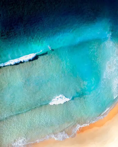 A lone surfer in the waves near the beach